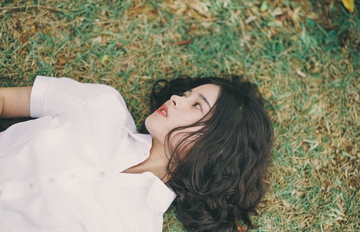 Woman lies in the grass by Shine Tang?width=719&height=464&fit=crop&auto=webp