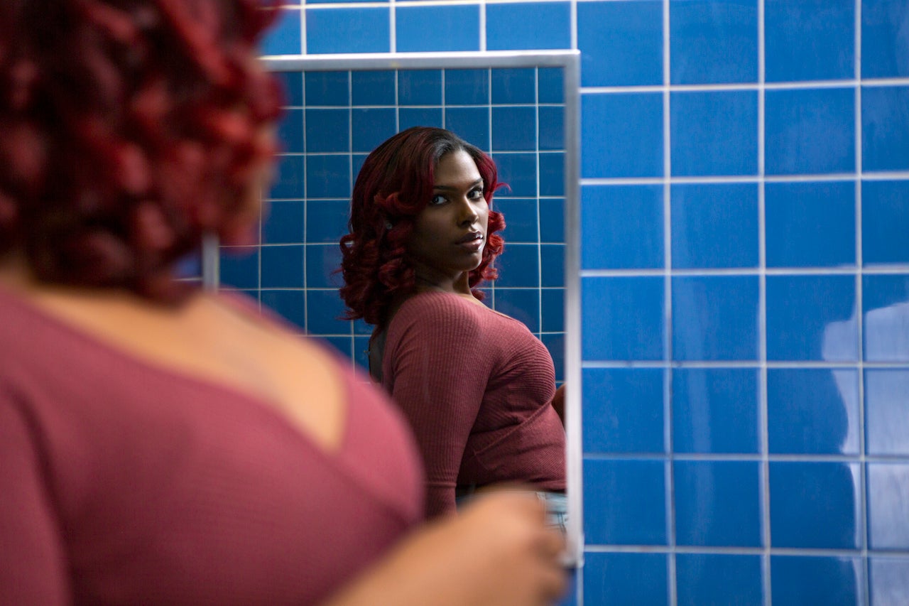 A young transgender woman looking at her reflection in a bathroom mirror?width=1024&height=1024&fit=cover&auto=webp