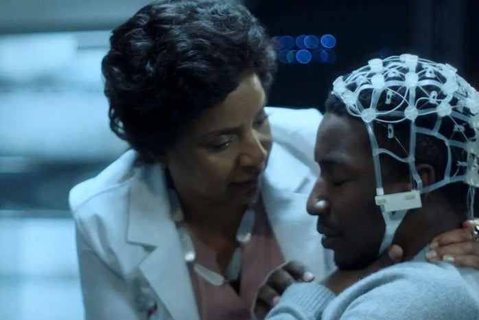 Still from Black Box; Specifically the image of Nolan with the EEG cap on and the doctor, Lillian, speaking to him.