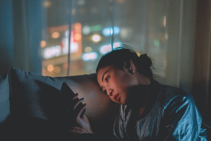 Woman staring at phone at night