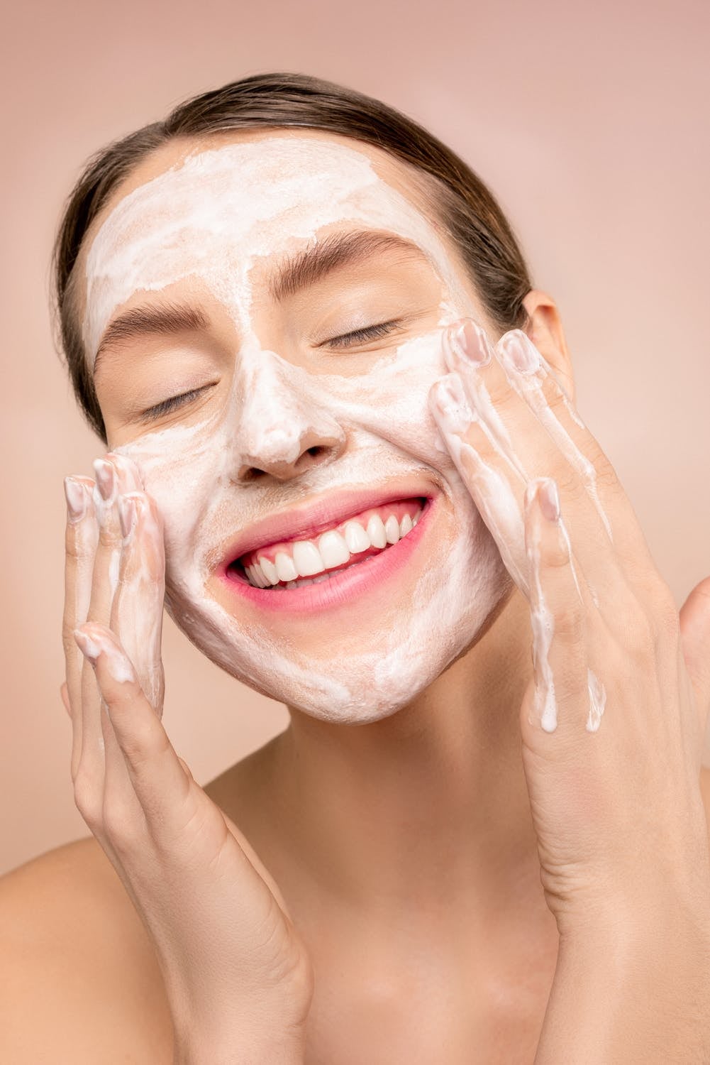 woman with facial soap washing their face