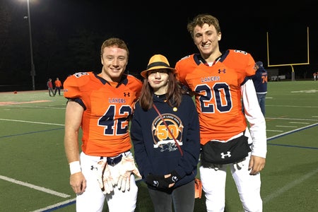 Girl in between two High School Football players