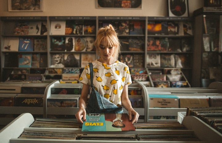 woman in a record store wearing a lemon shirt