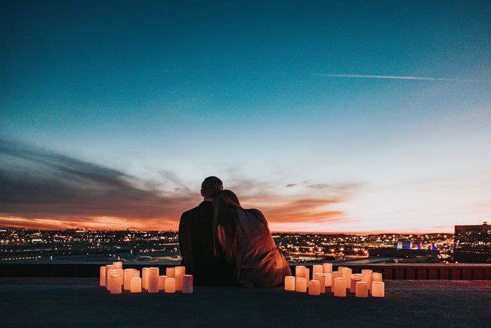 Couple sitting next to lights watching sunset