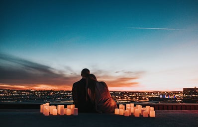 Couple sitting next to lights watching sunset