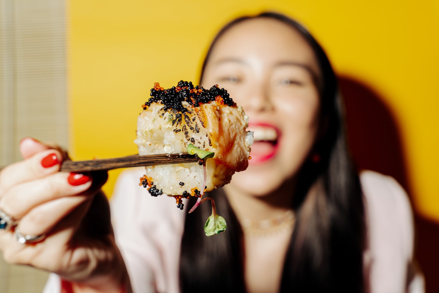Woman holding sushi on chopstick