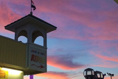 purple sky with sign that says "rides"