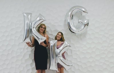 two women holding KKG balloons