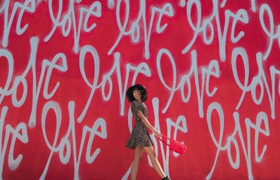 girl in front of love wall
