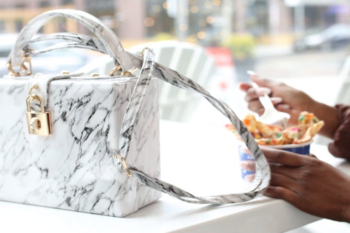 white purse with person eating dessert by Nappyco?width=698&height=466&fit=crop&auto=webp