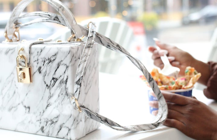 white purse with person eating dessert by Nappyco?width=719&height=464&fit=crop&auto=webp