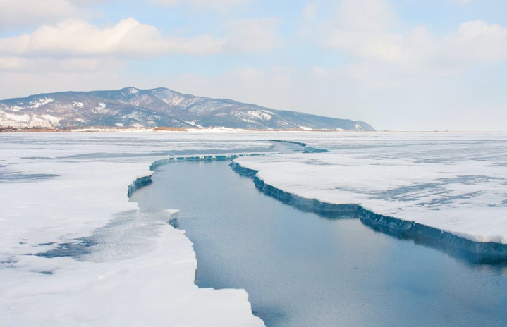 snow covered mountain near body of water during daytime at lake baikal in siberia, russia
