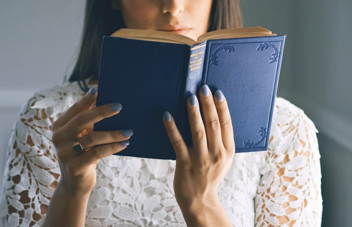woman wearing white floral top reading bible
