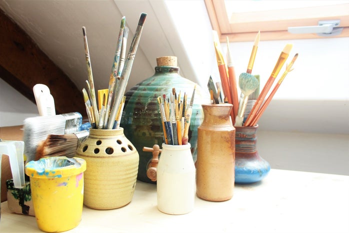 paintbrushes in pots on a table