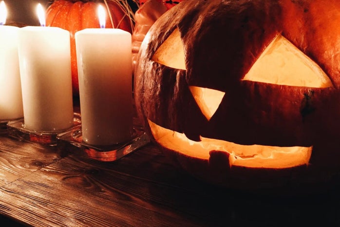 Carved pumpkin on table with candles