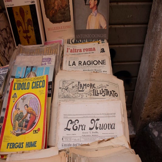 Multiple vintage newspapers on a table in Italian