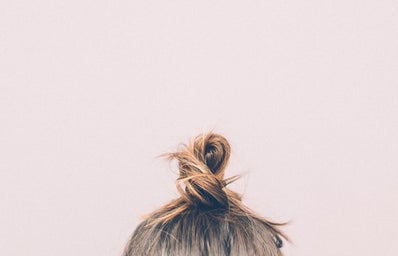 top of a woman\'s bun on a neutral colored background