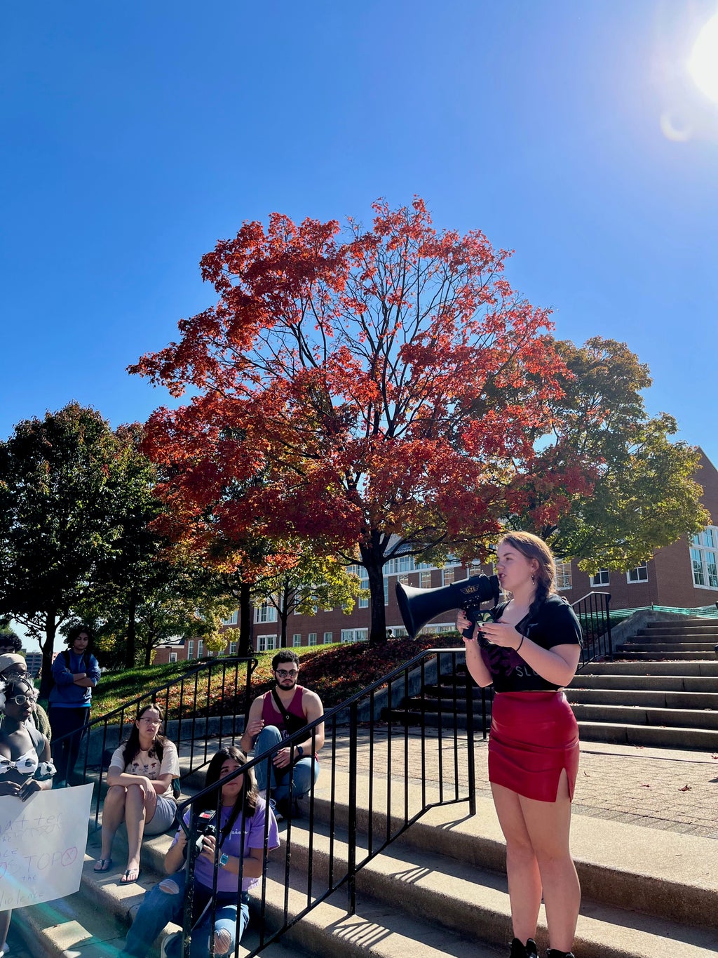 A photograph of a speaker at the “slut walk” preventing sexual assault event. The speaker is student Anna Gerstein.