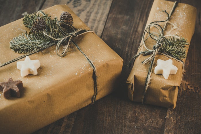 two gifts are wrapped in brown paper and covered with green and star-shaped soaps.
