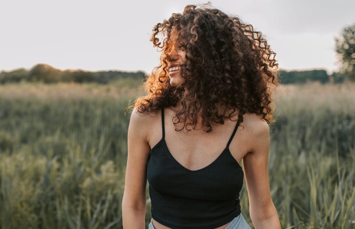 woman with curly hair in field by Vlada Karpovich?width=719&height=464&fit=crop&auto=webp