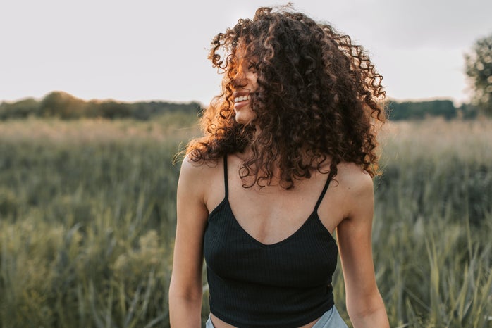 woman with curly hair in field by Vlada Karpovich?width=698&height=466&fit=crop&auto=webp