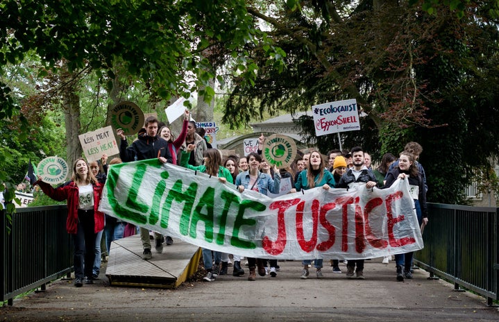 people marching with sign that says "climate justice"