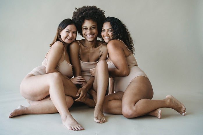 three women in brown tank tops and shorts against a white backdrop