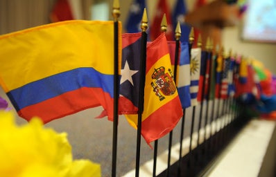 Miniature flags representing Hispanic nations line a table