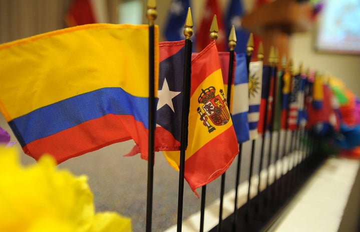 Miniature flags representing Hispanic nations line a table