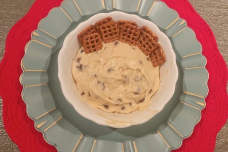 Cookie Dough Dip with Dipping Pretzels is Served in A White Bowl on top of a red and blue placemat display