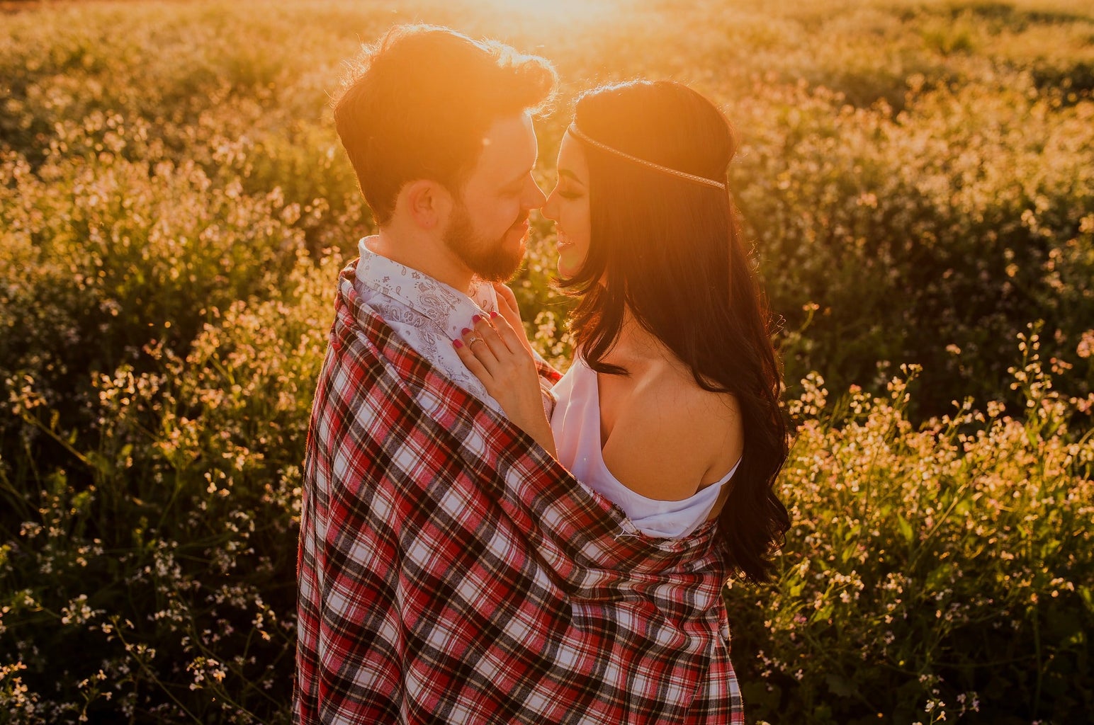 Young couple hugging at sunset in field