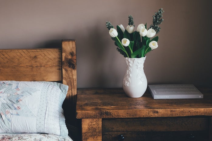 white flowers in vase on bedside table