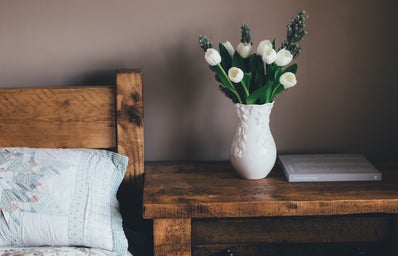 white flowers in vase on bedside table