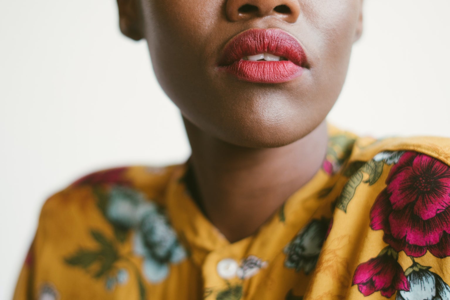 Bottom half of black african woman's lips with pink lipstick