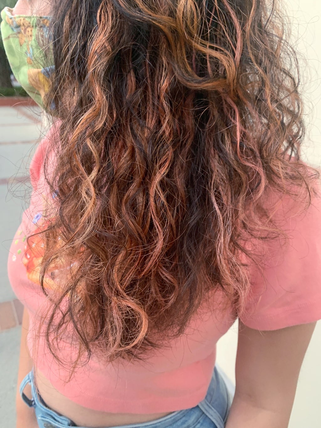 A closeup side photo of rose gold curly hair.