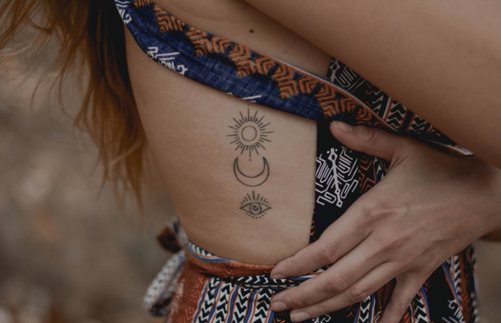 set of minimalistic tattoos on a person's ribcage