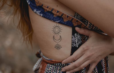 set of minimalistic tattoos on a person's ribcage