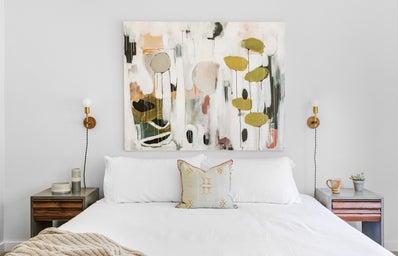 White bedspread with pink and olive green wall painting