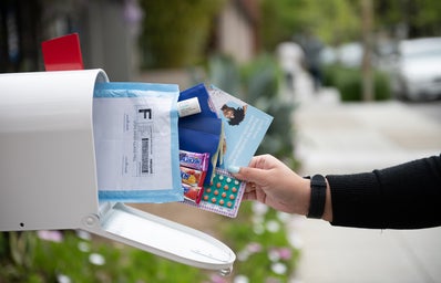A mailbox with medicine, flyers, and candy coming out
