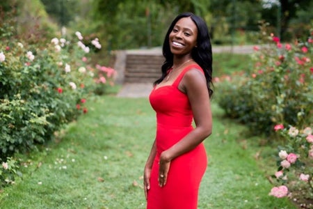woman with red dress in grassy/floral area.