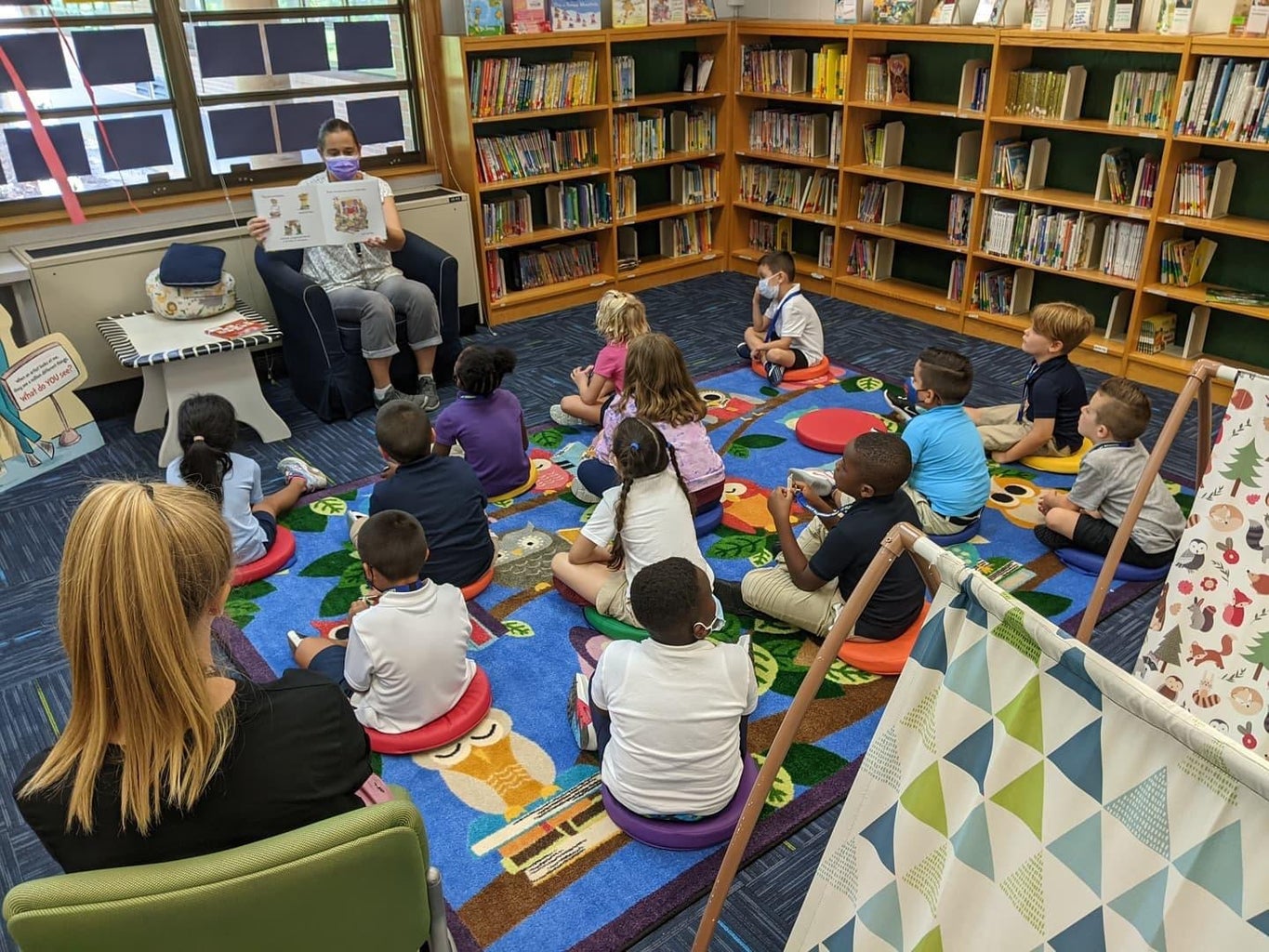 woman reading to group of kids