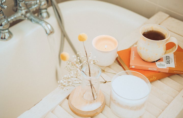 Tea cup and candle by a bath tub