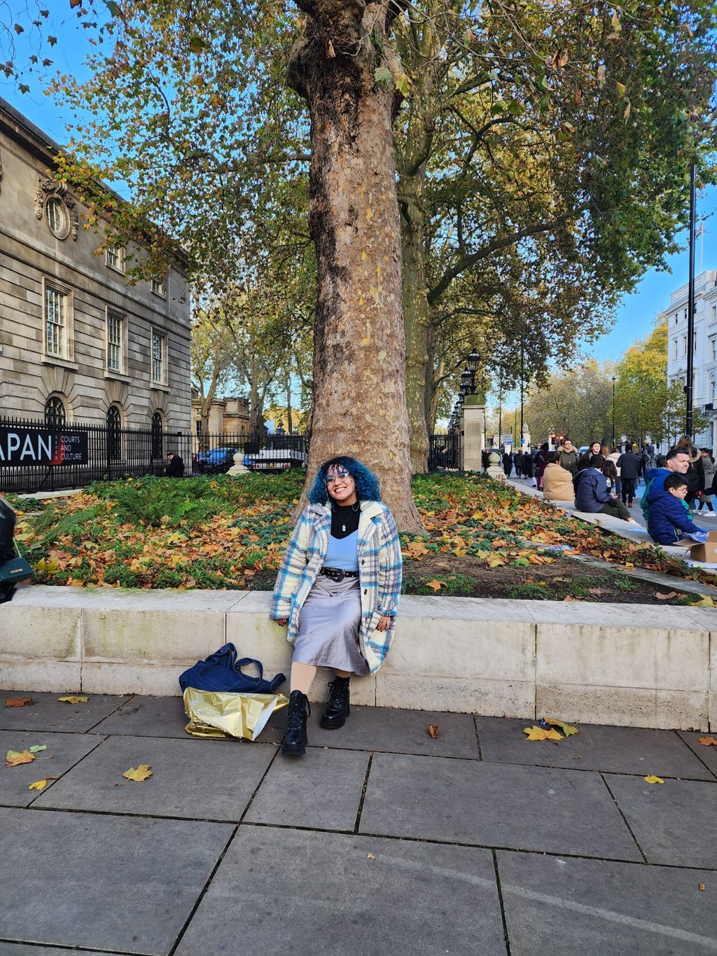 Person (me) sitting in London outside the Queens Gallery