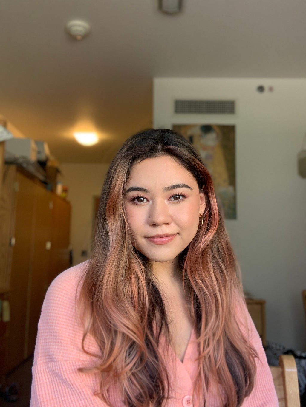 A portrait of a woman with rose gold highlights.