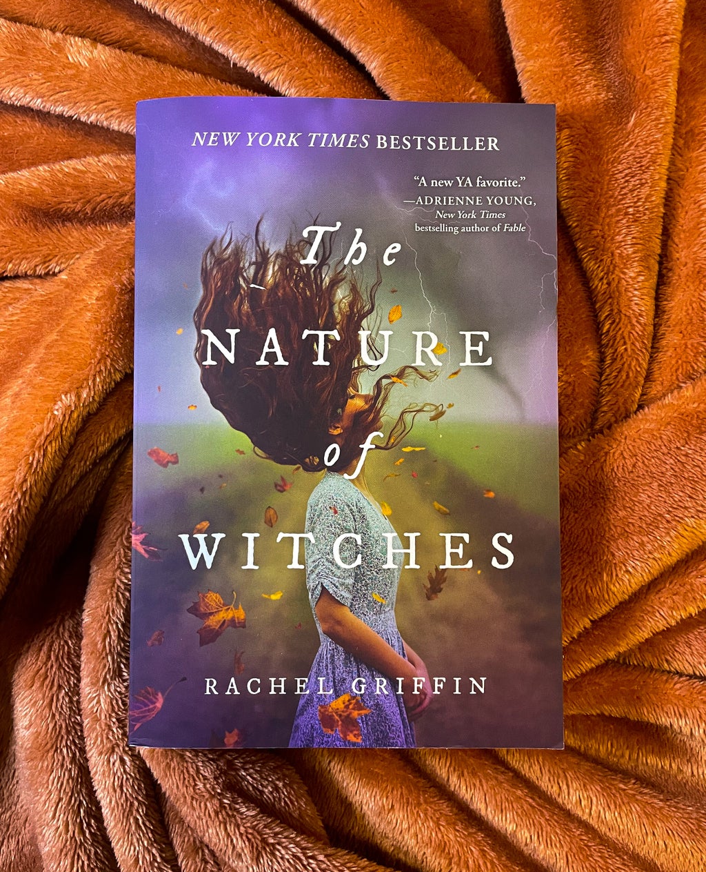 The Nature of Witches by Rachel Griffin on orange blanket