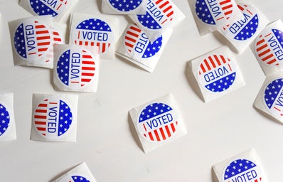 I Voted stickers scattered on a white surface