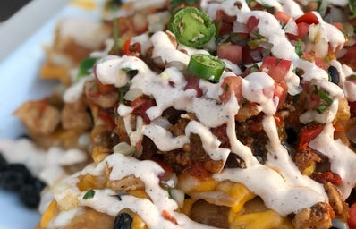 Plate of nachos covered in cheese and toppings