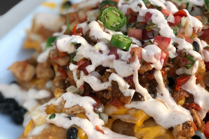 Plate of nachos covered in cheese and toppings