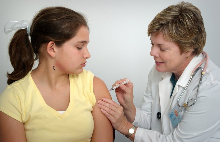 doctor giving girl vaccination