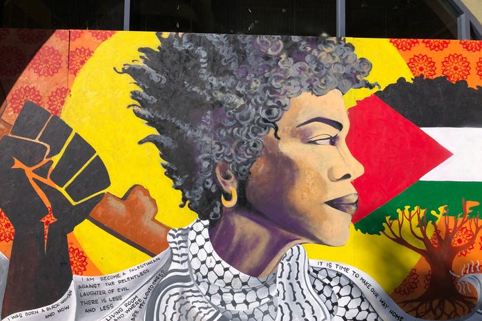 Painting of an African American woman, the Black Lives Matter logo and and a tree with the Palestinian flag.